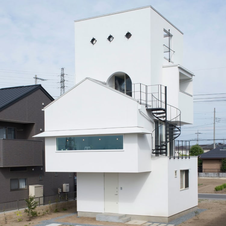 川のほとりに立つ白い塔の家 - 株式会社下田設計